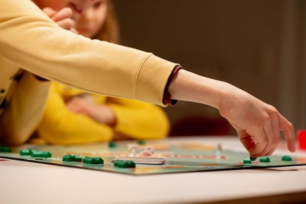 A close-up shot of hands moving game pieces on a complex board game. The focus is on the tactile interaction and strategic thinking involved in the game.