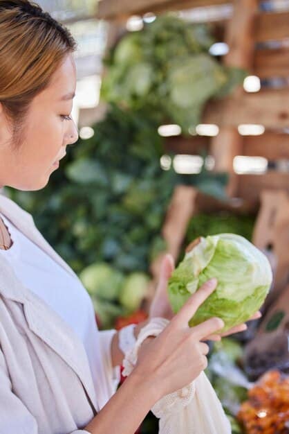 A chef carefully inspecting fresh produce at a local farm, with rows of crops visible in the background. The scene emphasizes the importance of farm-to-table sourcing and sustainable agriculture.