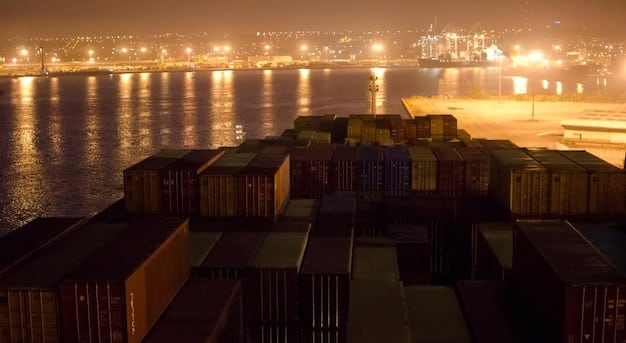 A cargo ship at a busy port, with containers being loaded and unloaded. The sky is slightly overcast, symbolizing the uncertain economic climate due to international trade sanctions.